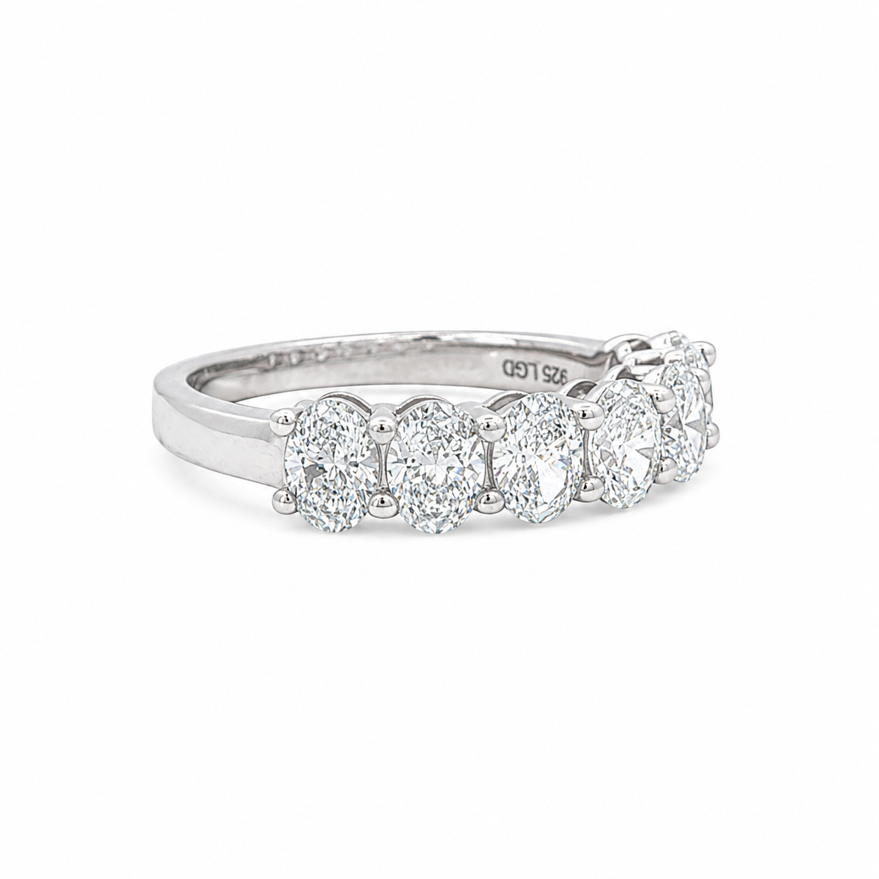 A silver diamond eternity ring featuring five round-cut diamonds set in a polished silver band, shown on a clean white background.