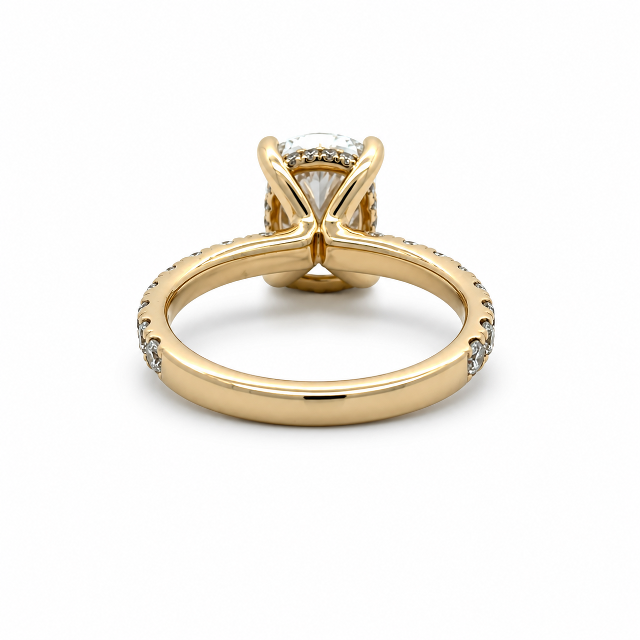 A yellow gold solitaire engagement ring with a round-cut center stone and small accent diamonds along the shank, shown on a plain white background.
