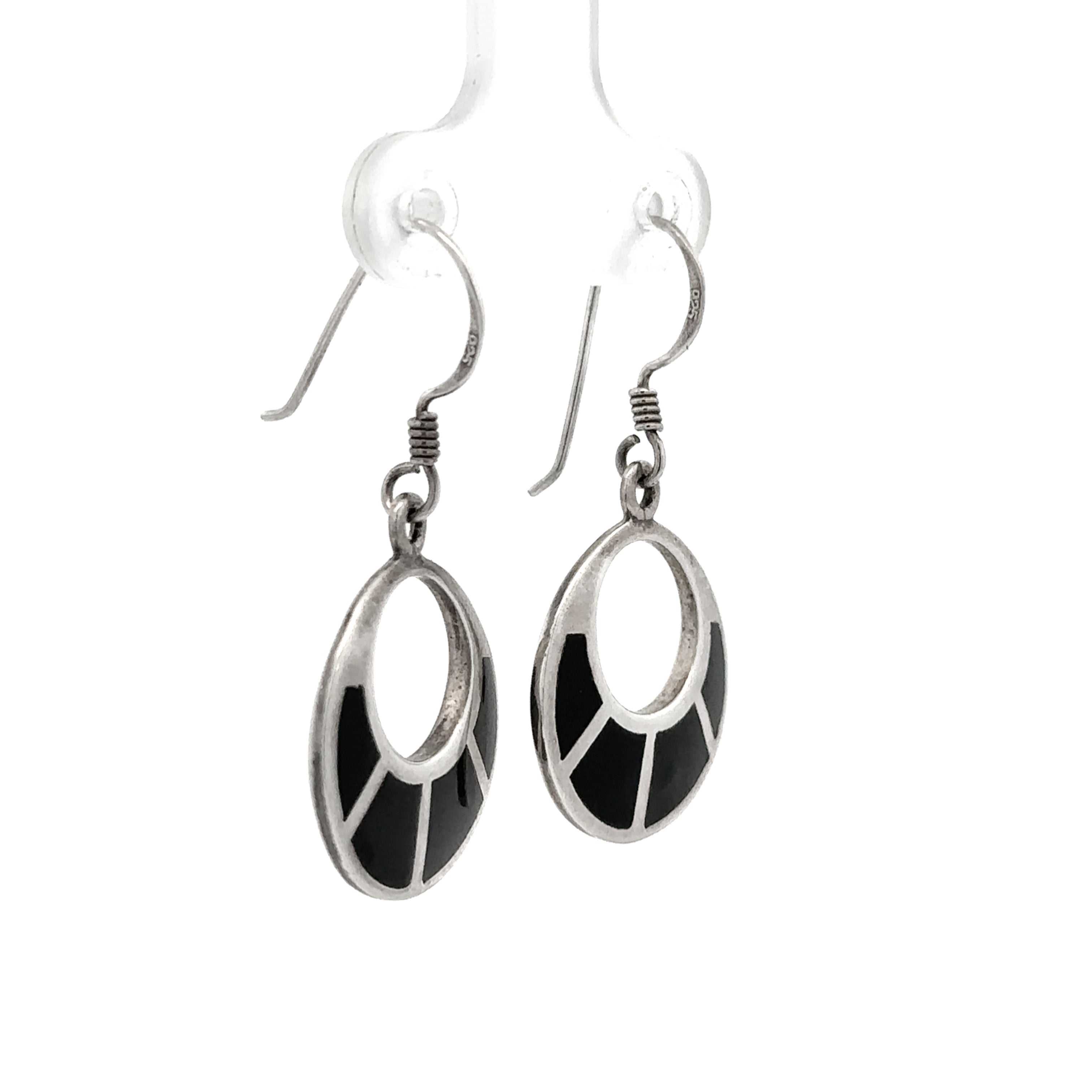 A pair of silver-toned drop earrings with oval cutouts and black inlay details, shown against a plain white background.