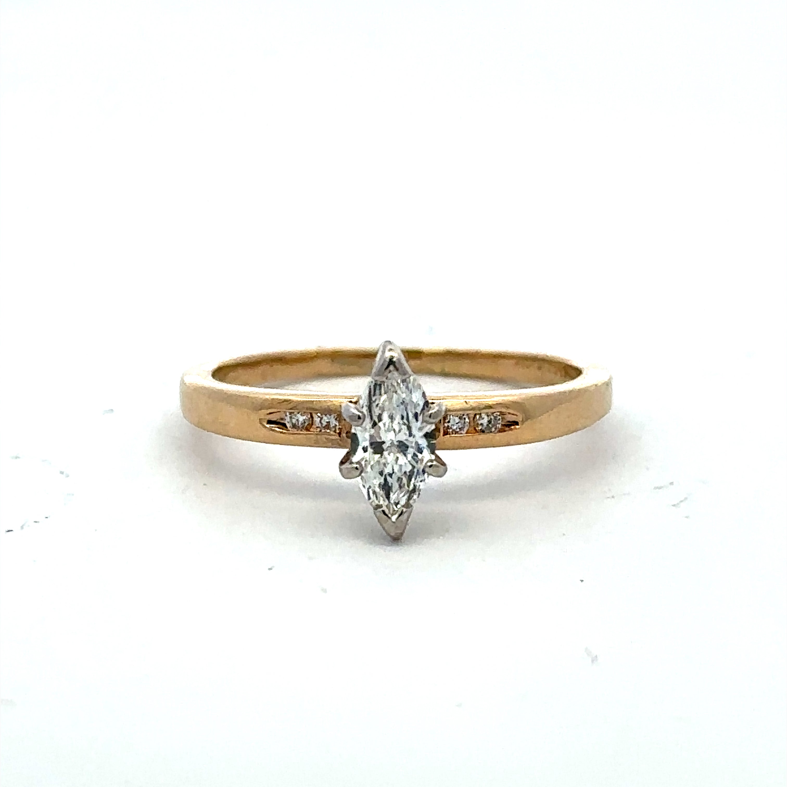A yellow gold ring featuring a marquise-cut diamond center stone with small accent diamonds on either side of the band, set against a plain white background.