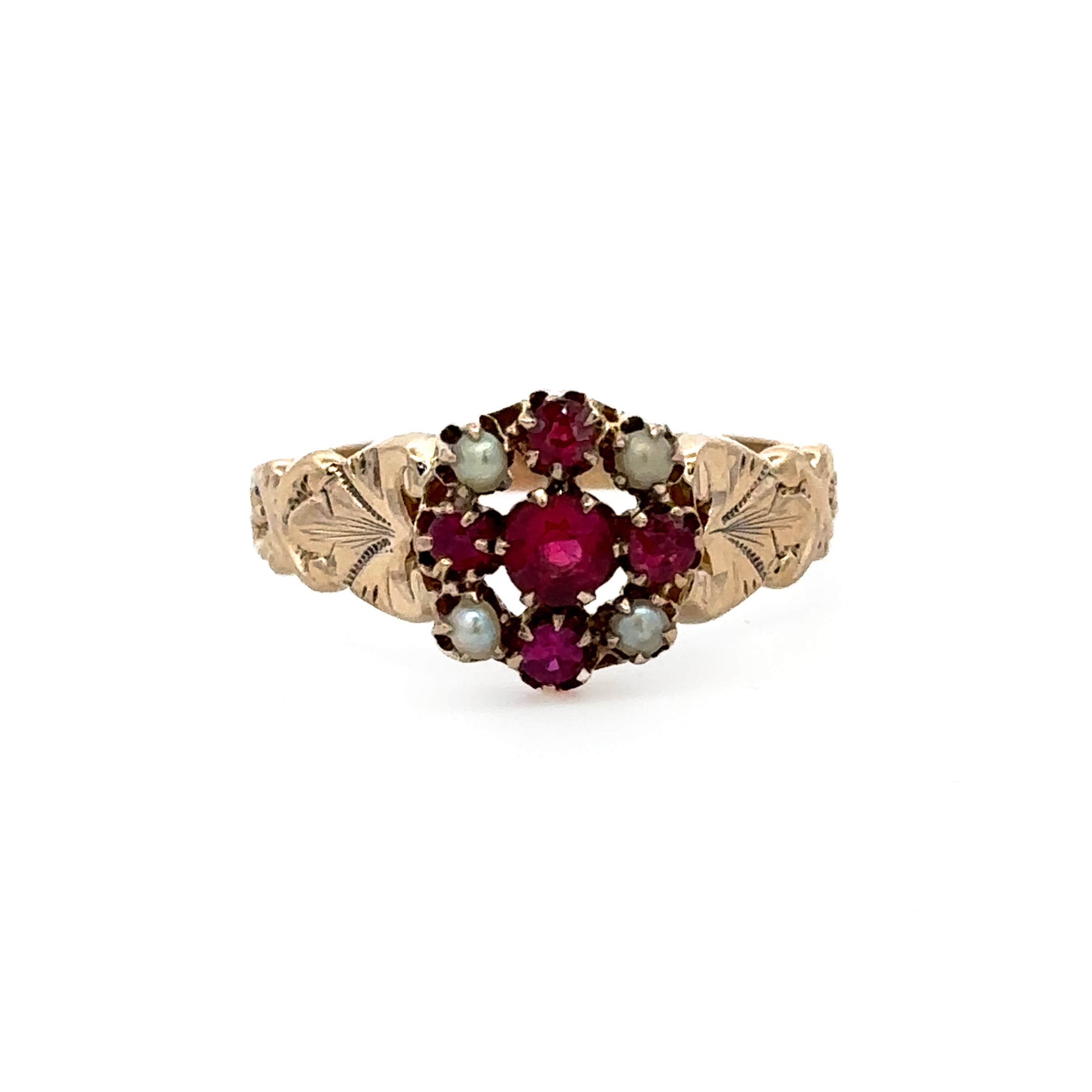 A vintage-style gold ring featuring a floral cluster with deep red round gemstones and pale gray-green oval stones, set on a delicate leaf-patterned band against a plain white background.