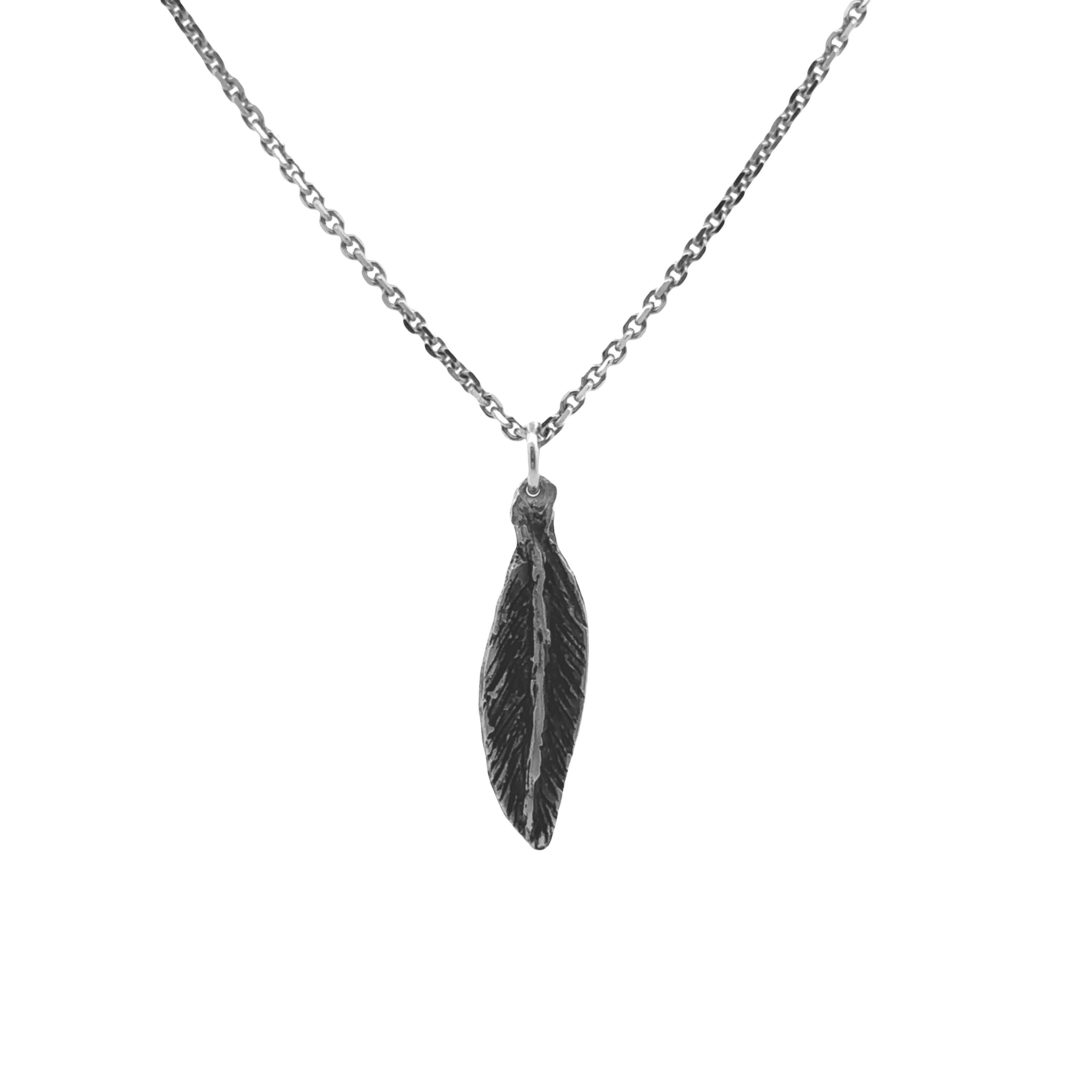 A silver-toned necklace featuring a textured feather pendant, shown against a plain white background.