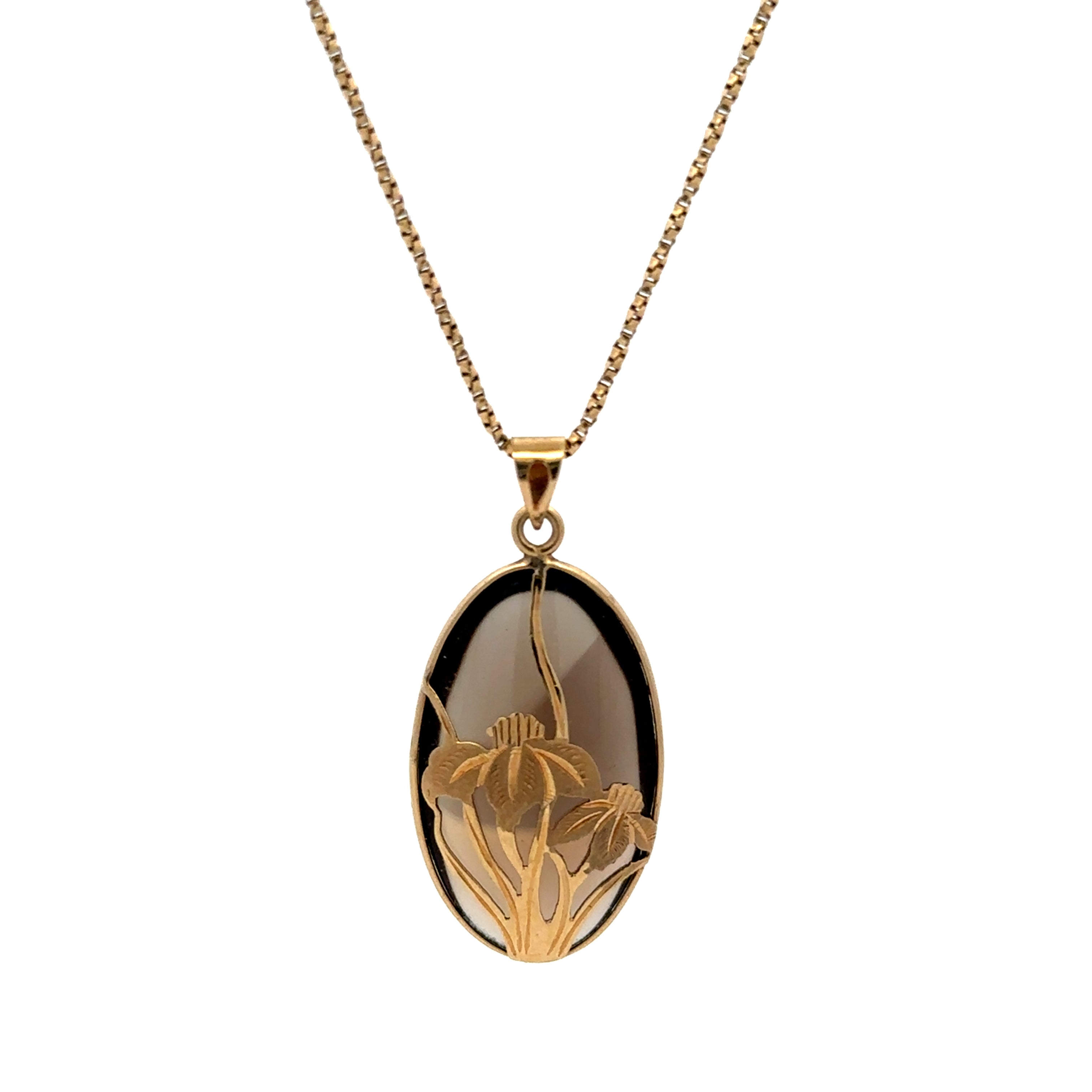 A gold chain necklace with an oval pendant featuring a black and smoky brown gradient background with a gold floral engraving, shown on a plain white background.
