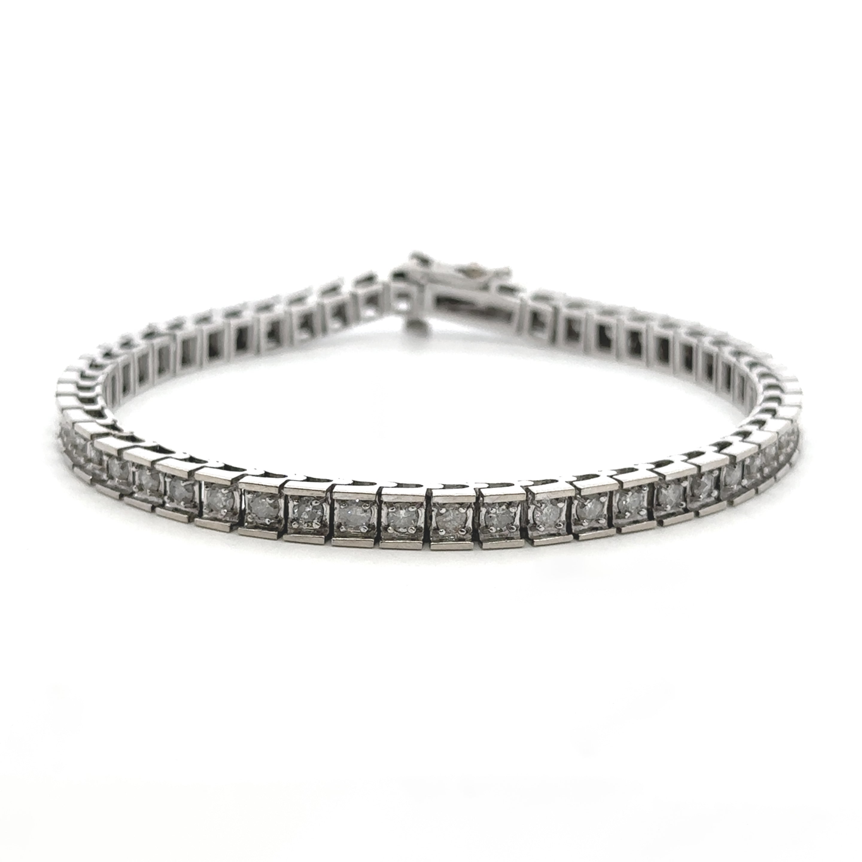 A silver tennis bracelet with a continuous row of round-cut clear gemstones in a prong setting, displayed on a clean white background.