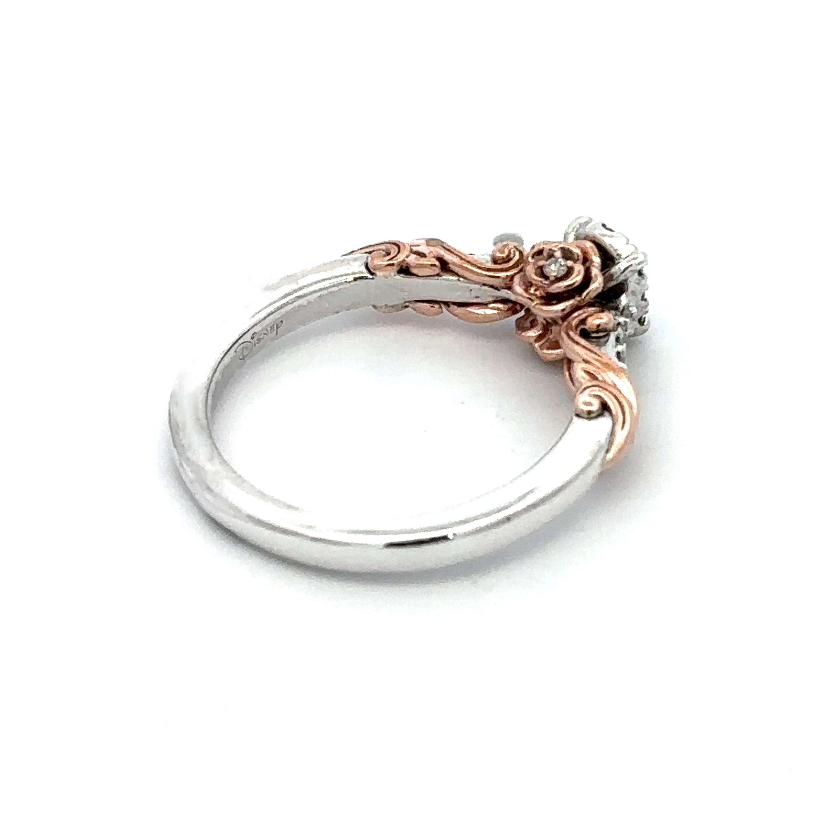 A two-tone ring featuring a polished silver band and a rose gold filigree accent leading to a clear gemstone cluster, shown on a white background.