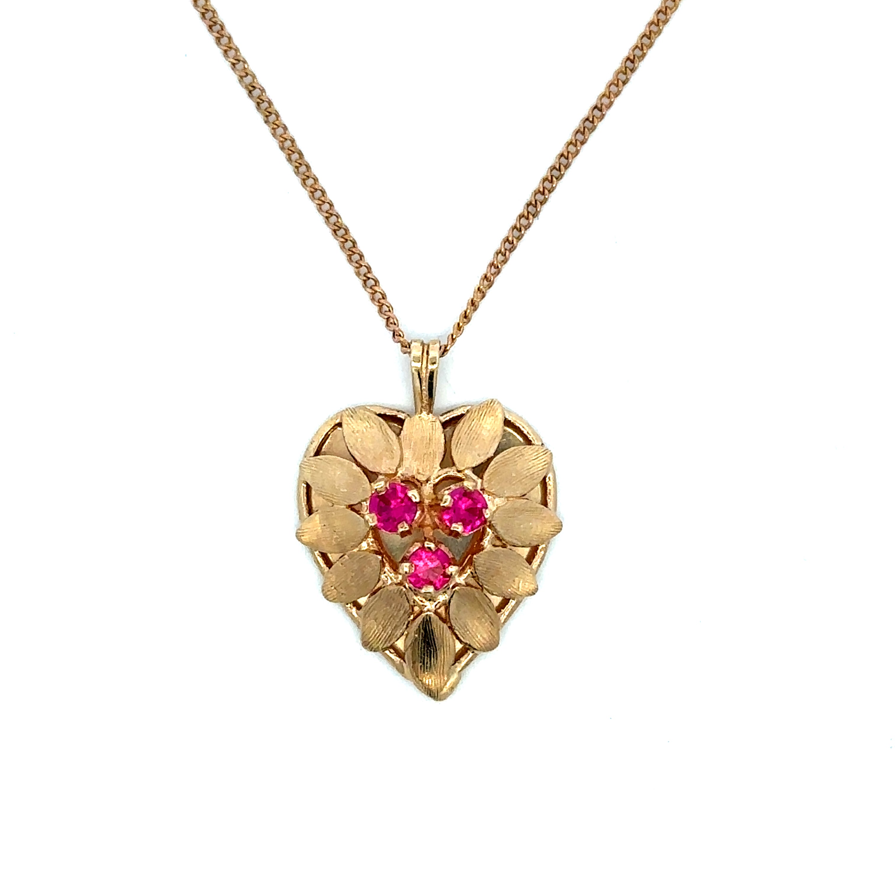 A gold heart-shaped pendant necklace featuring a textured petal design and three sparkling pink gemstones in the center, suspended from a delicate gold chain against a plain white background.