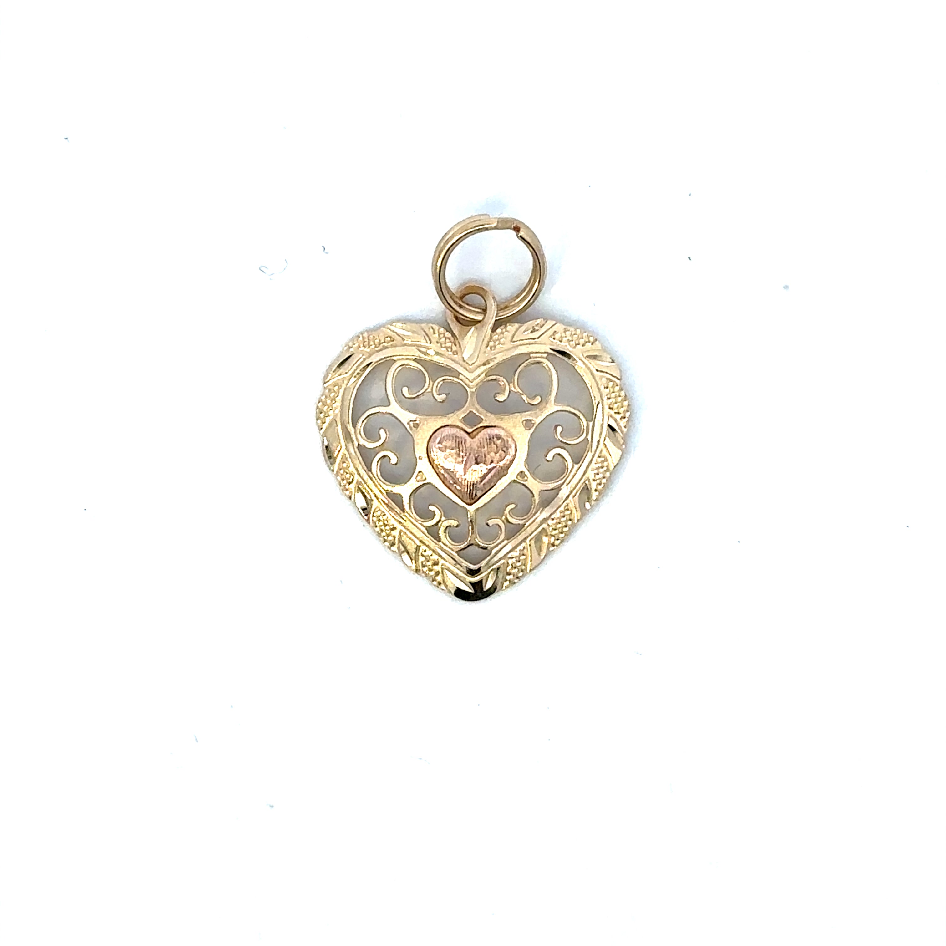 Gold heart-shaped pendant with intricate designs on a white background