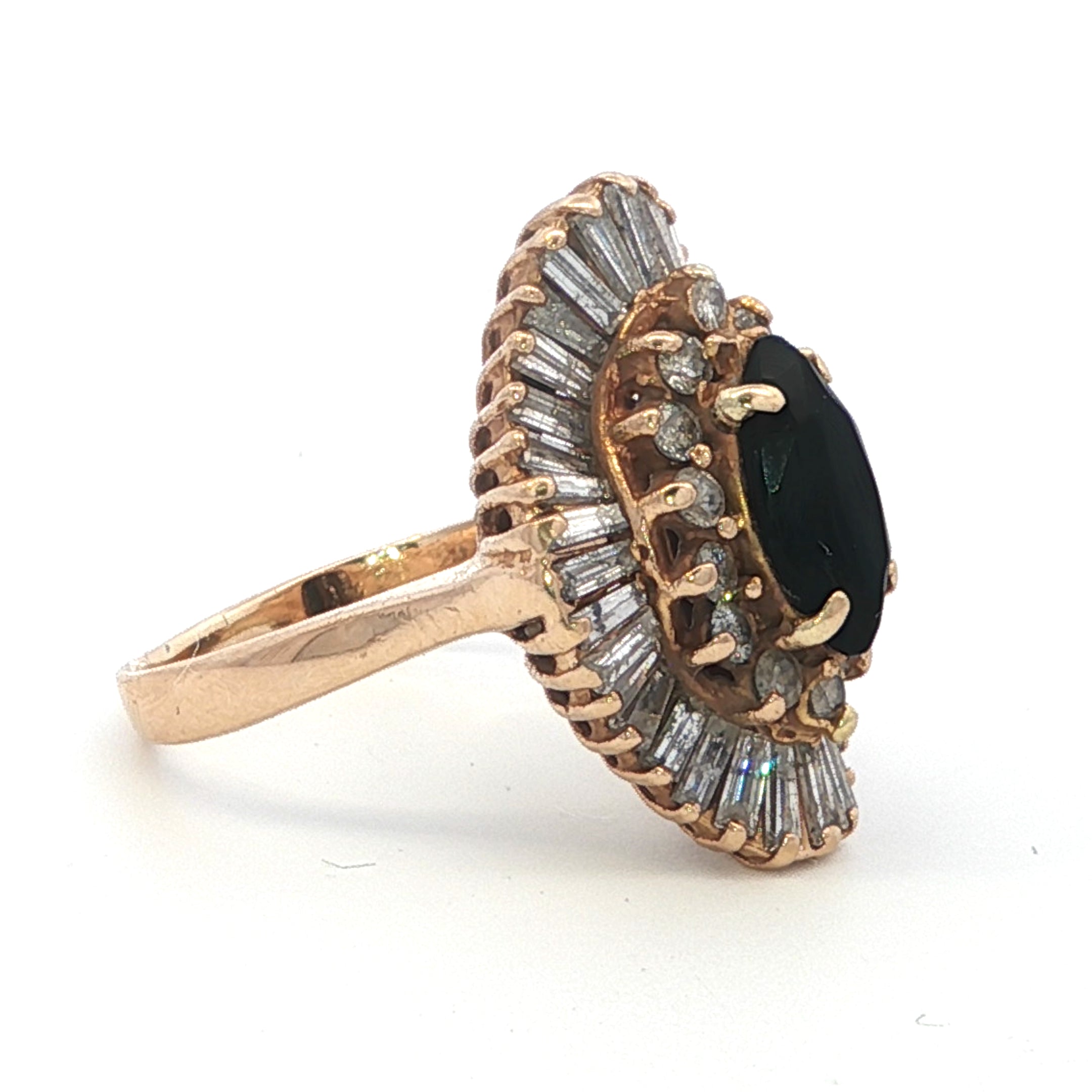 Rose gold ring with black gemstone and diamond accents on a white background