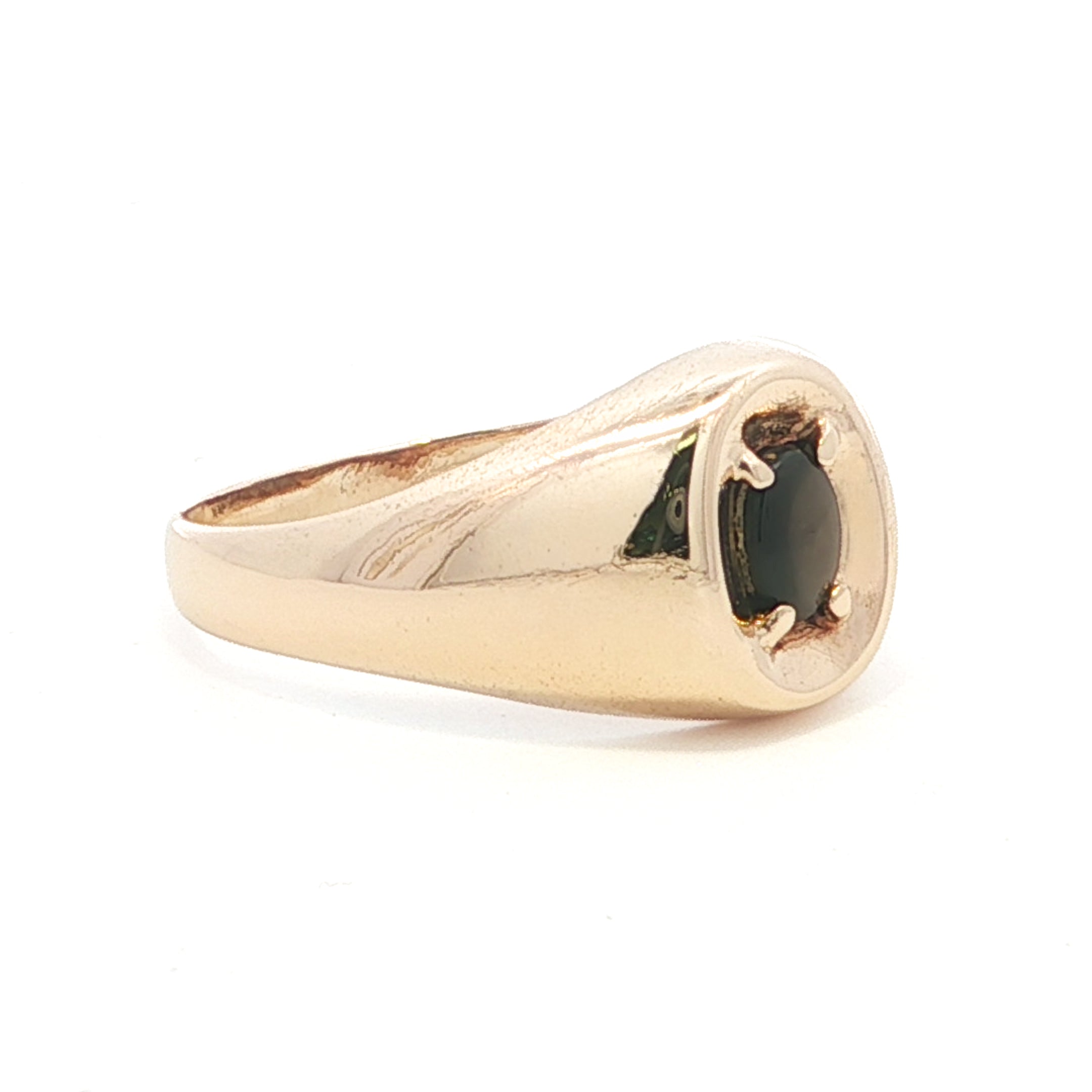 Gold ring with a black stone on a white background