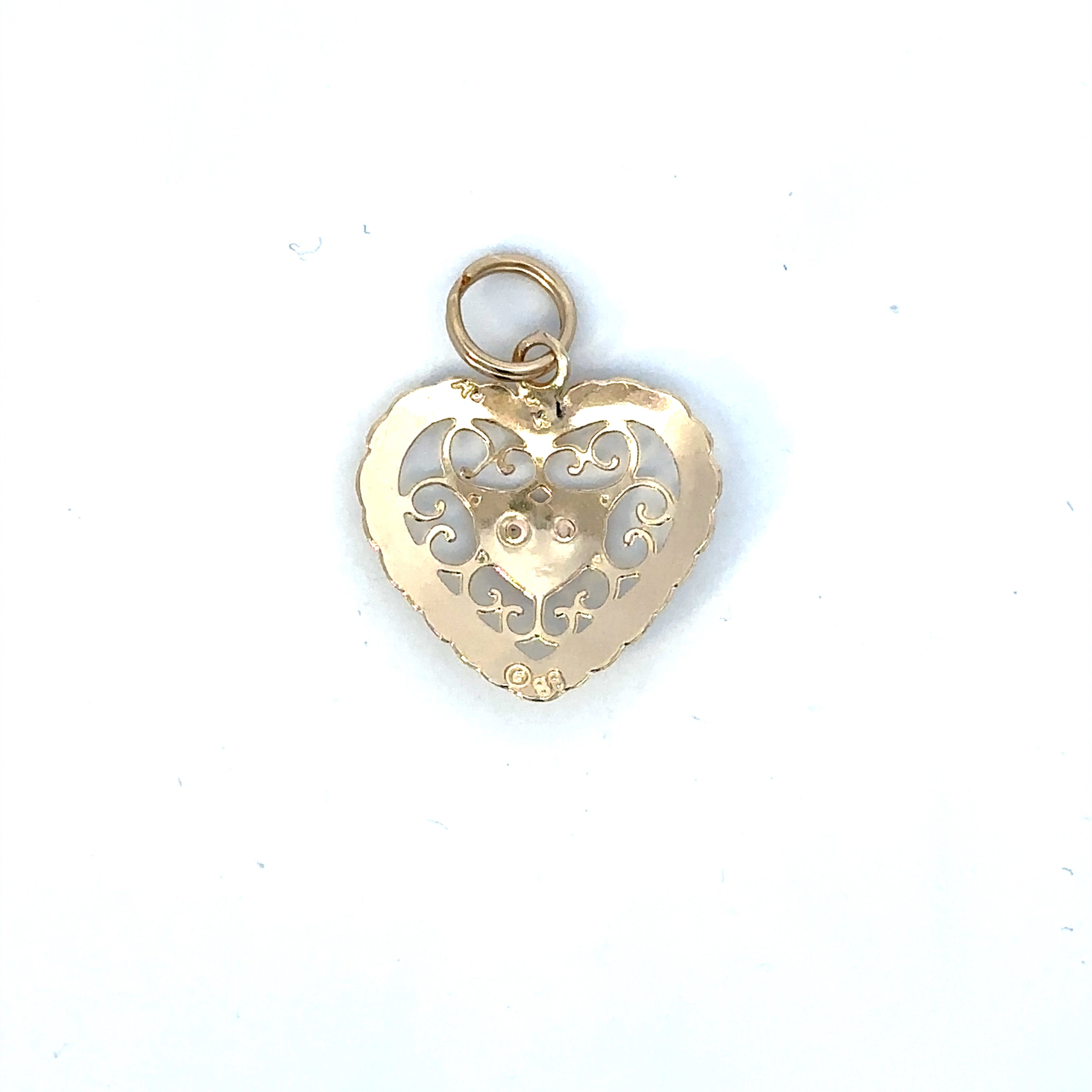 Gold heart-shaped pendant with intricate designs on a white background