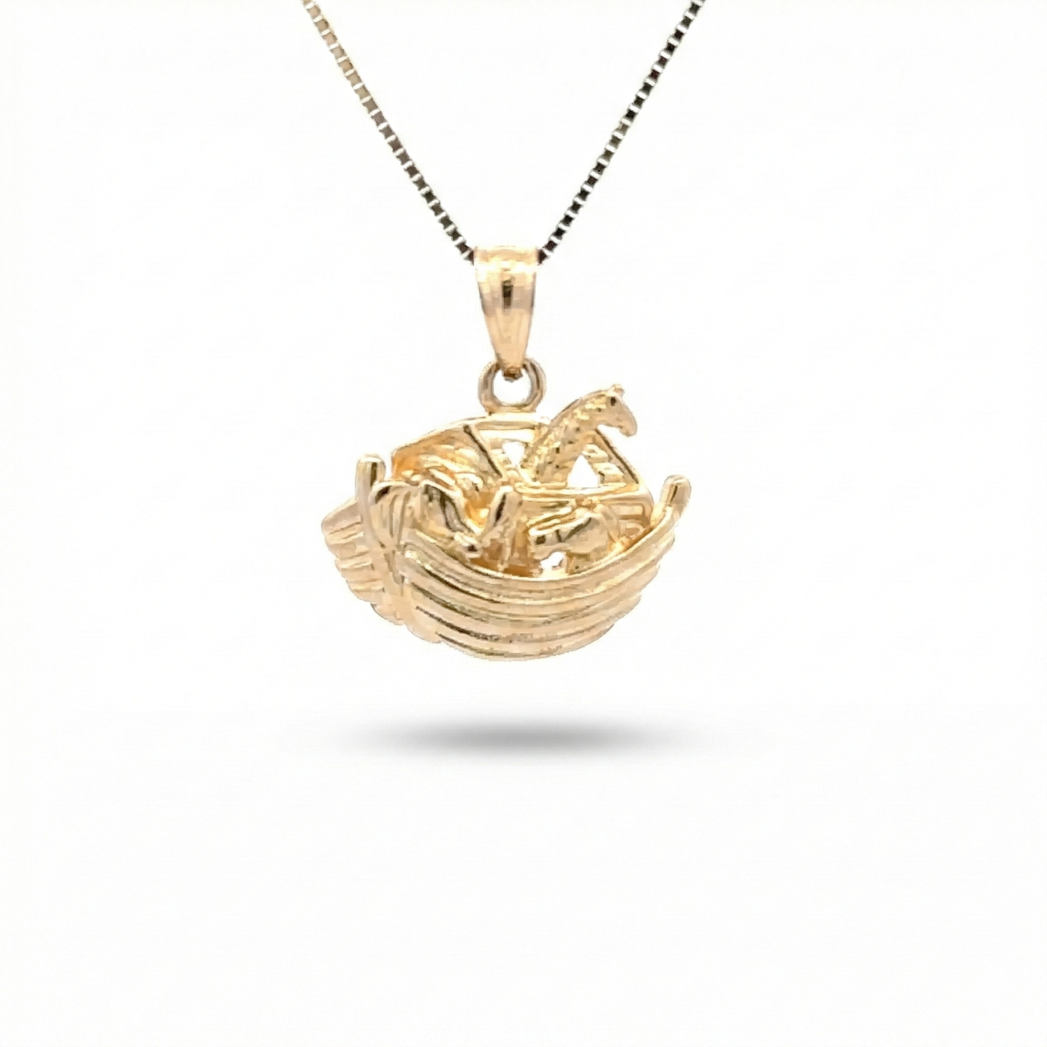 Gold necklace with a boat-shaped pendant on a white background