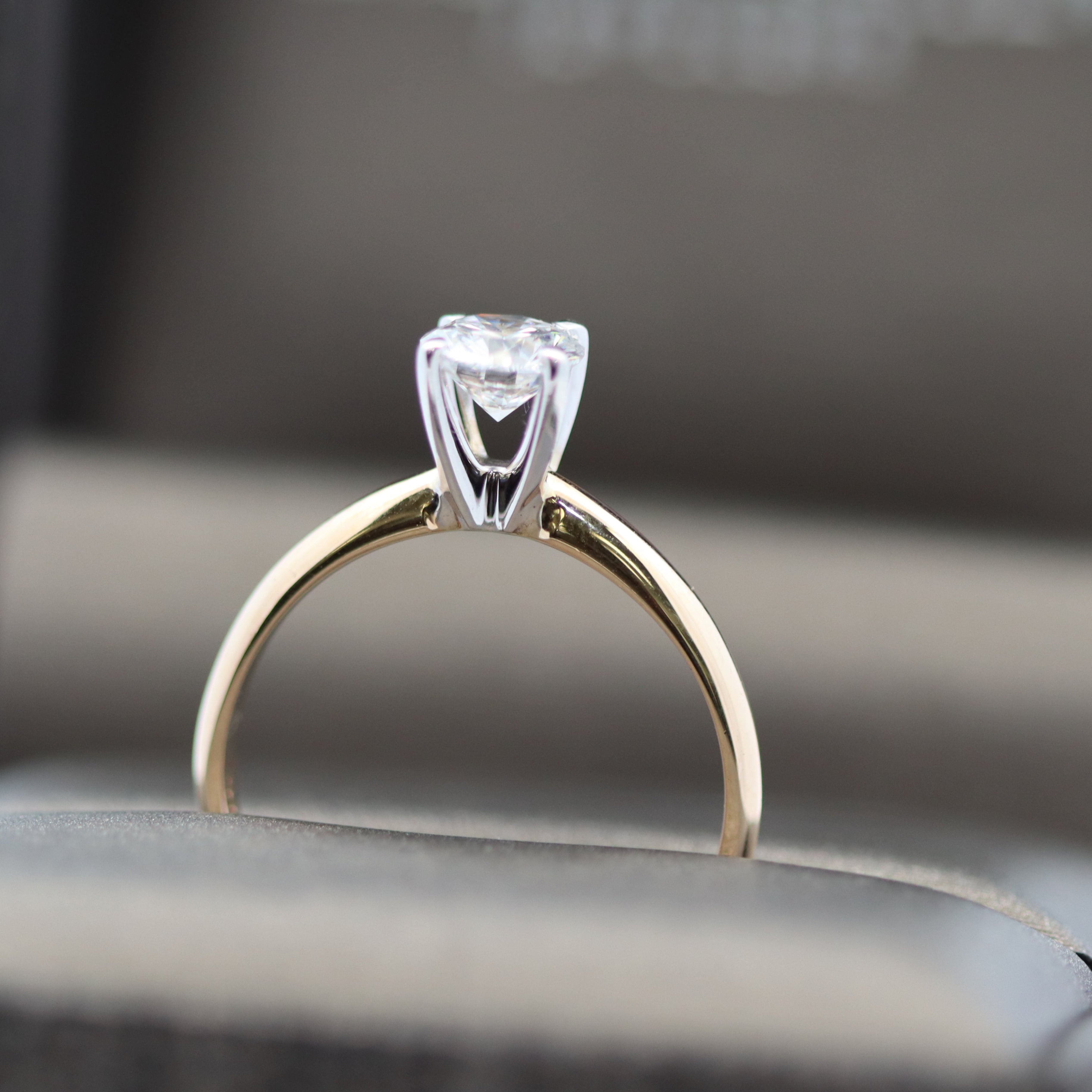 Gold ring with a diamond on a blurred background