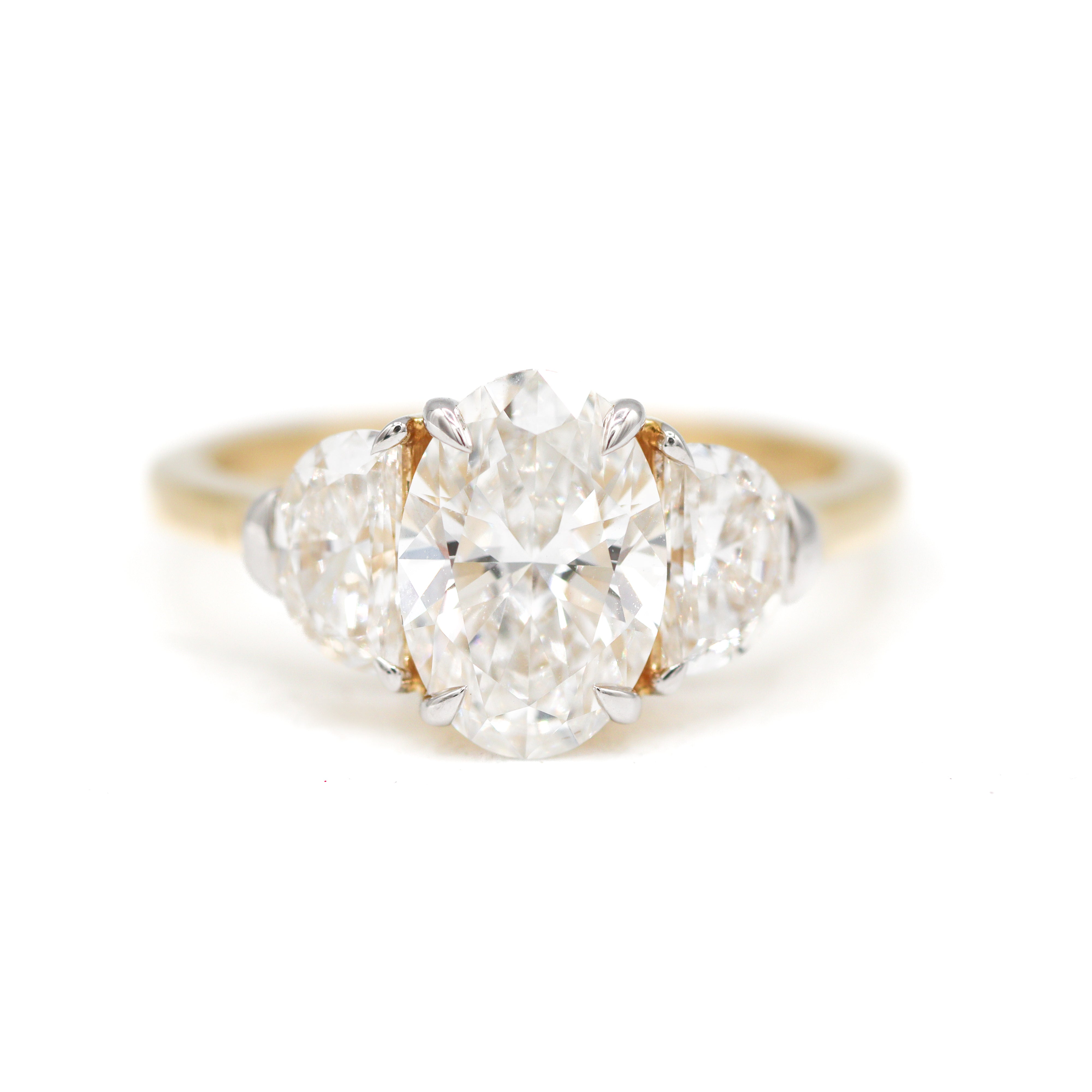 Front View of 2 Carat Oval Diamond Yellow Gold Ring with Half-Moon Diamonds on either side.