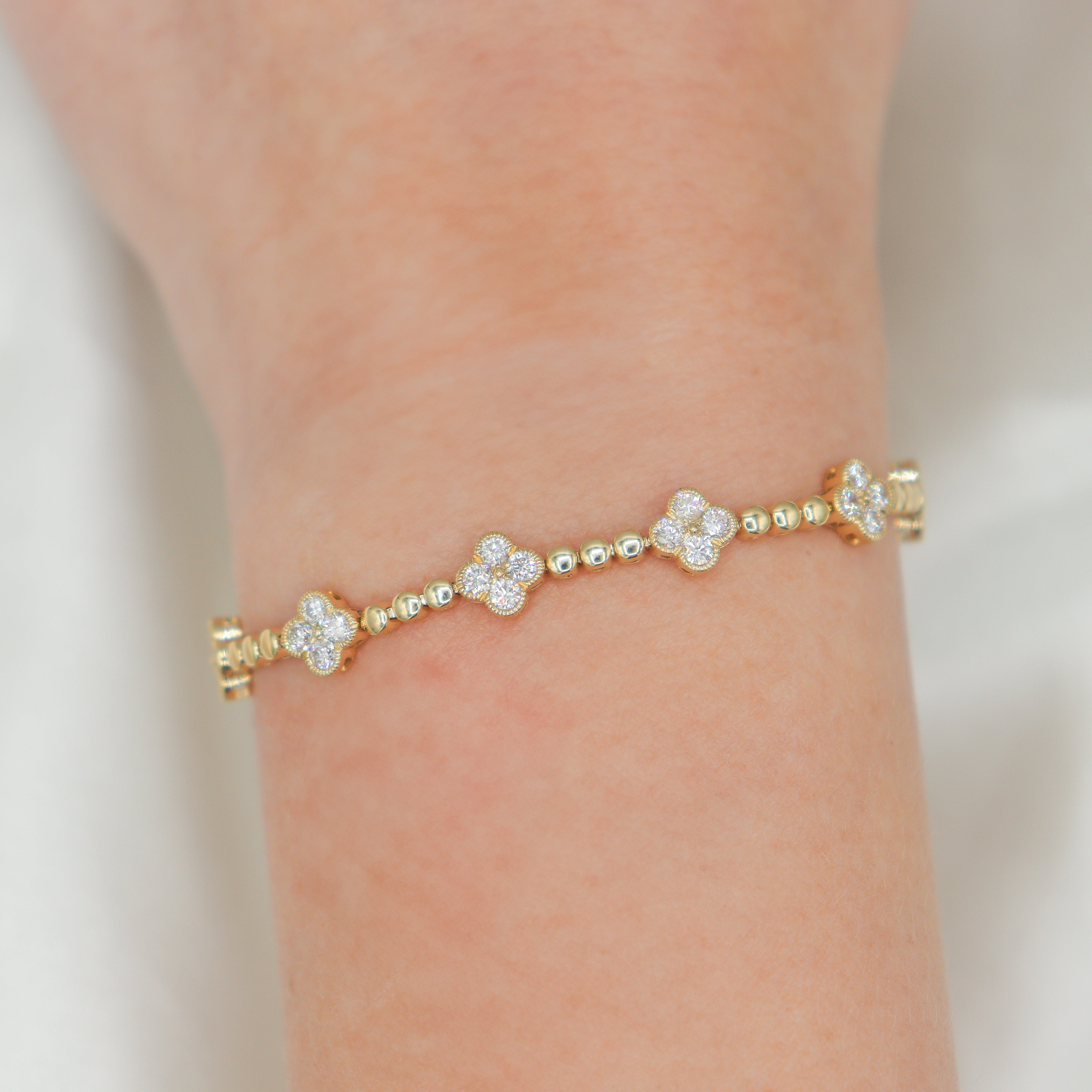 14K Yellow Gold Diamond Clover Station Tennis Bracelet on a wrist