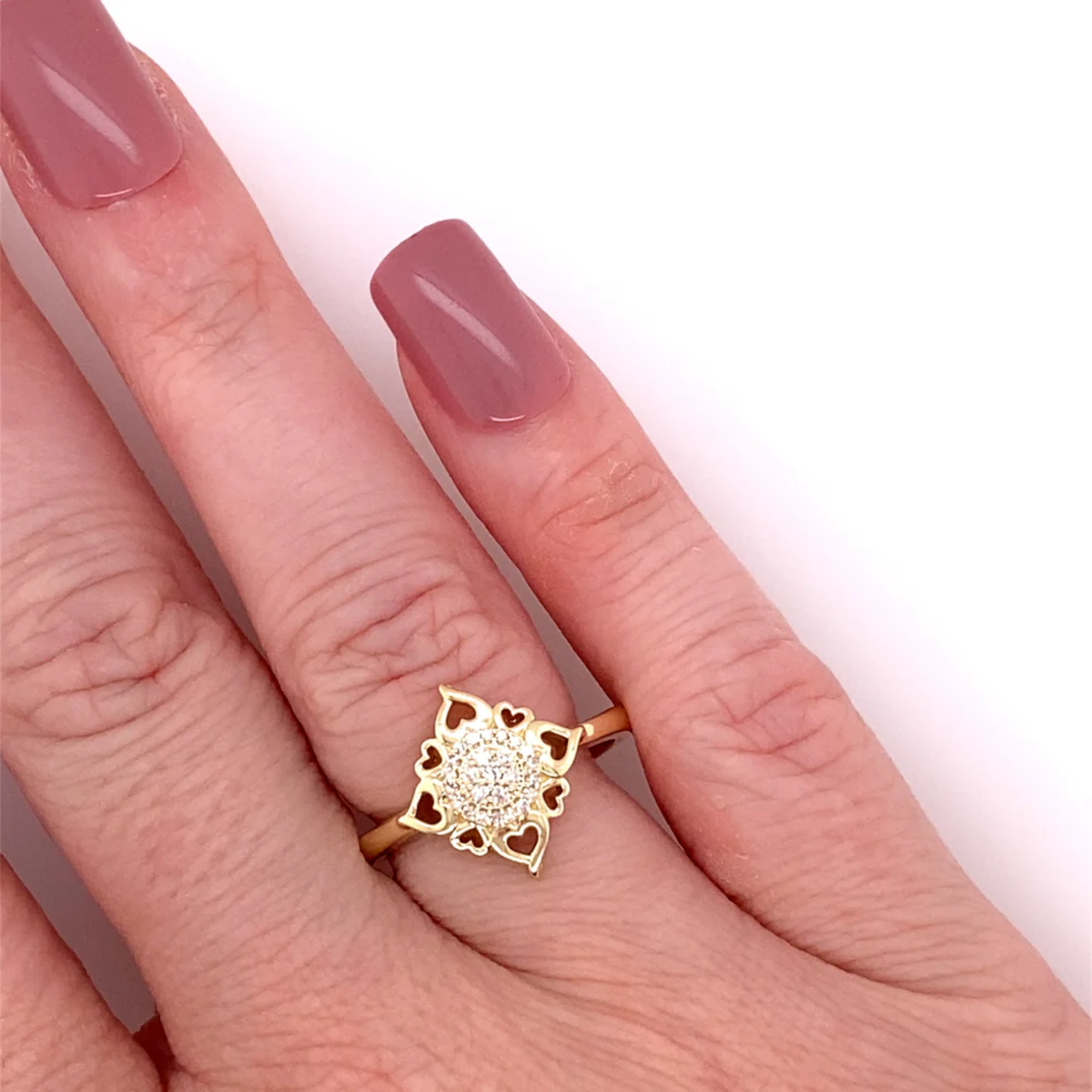 Gold ring with a diamond on a hand against a white background