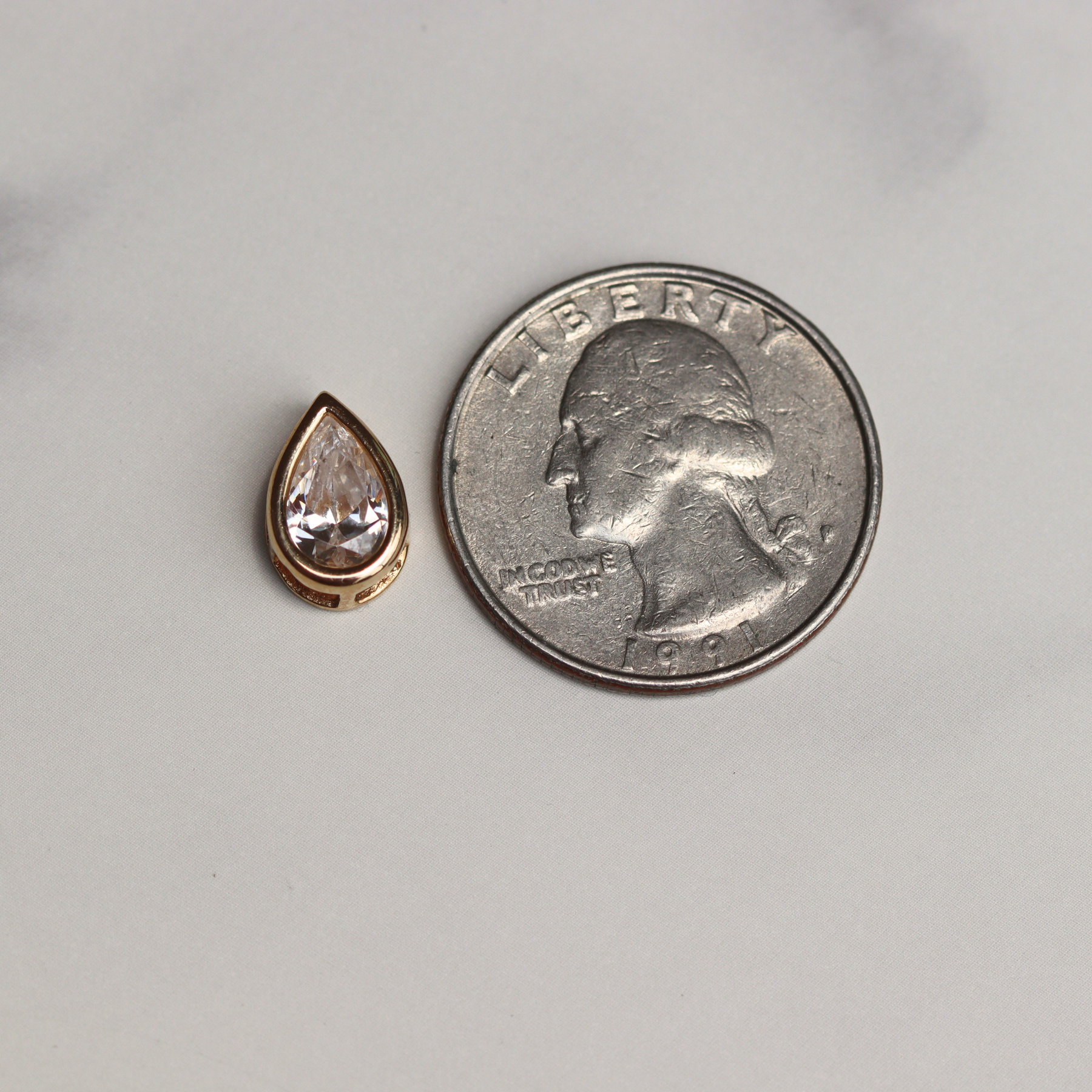 14k yellow gold slide pendant beside a quarter for scale