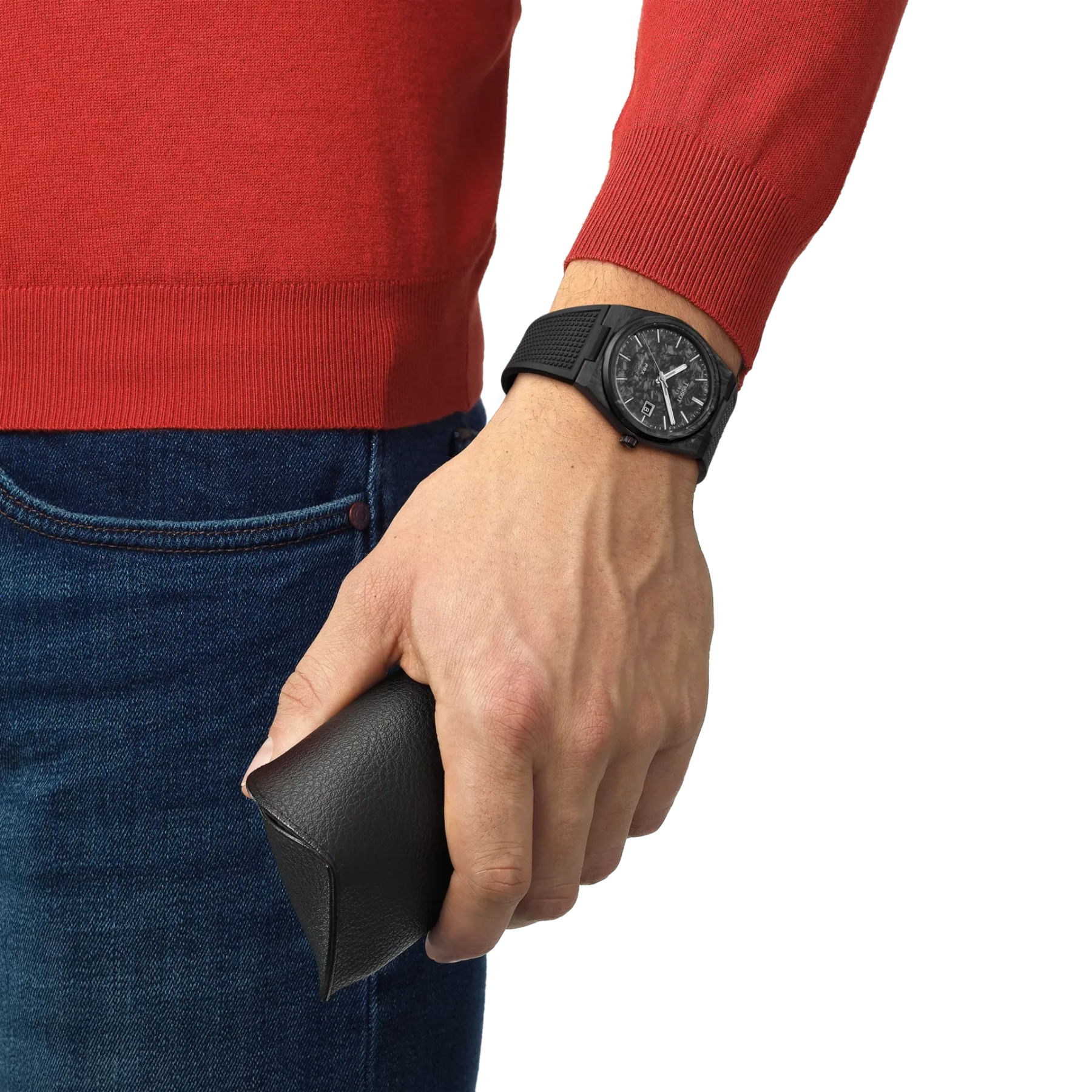Hand wearing a black watch holding a black wallet, with red sweater and blue jeans on a white background