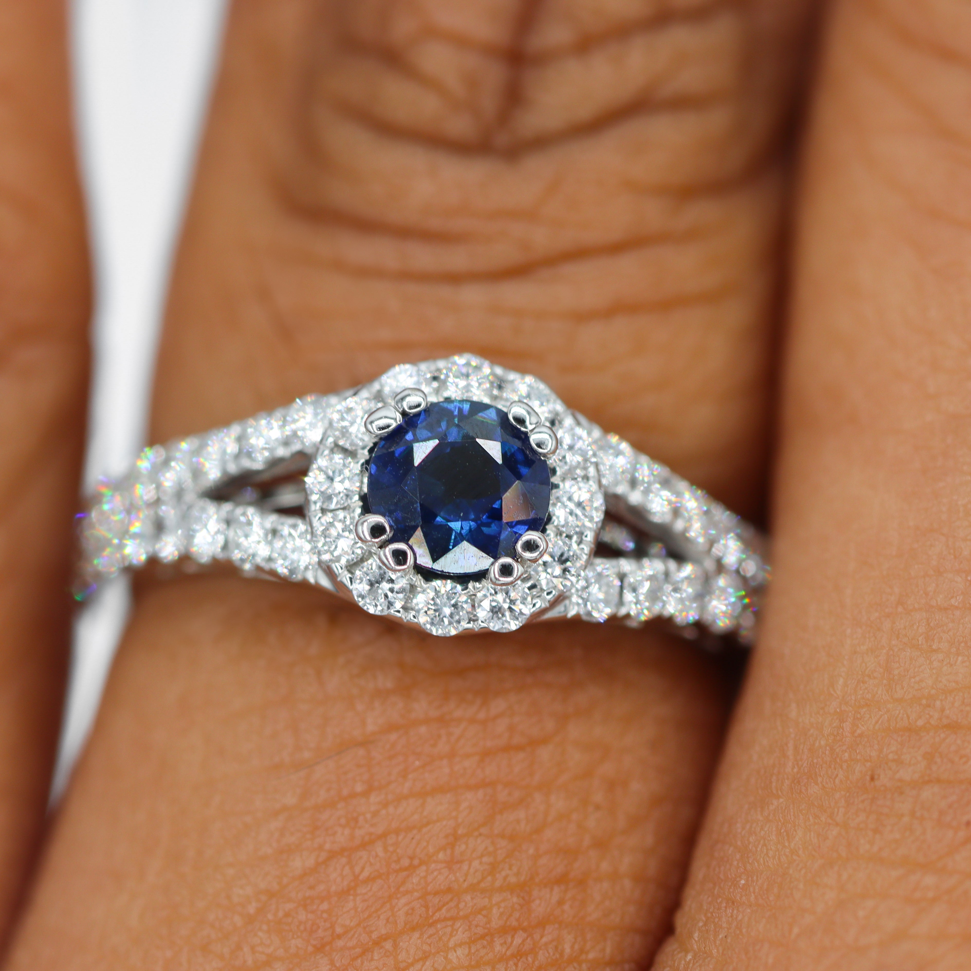 Top view of 18K White Gold 5/8CT. Sapphire with 3/4CT. Diamond Halo Split-Shank Engagement Ring on model's finger.