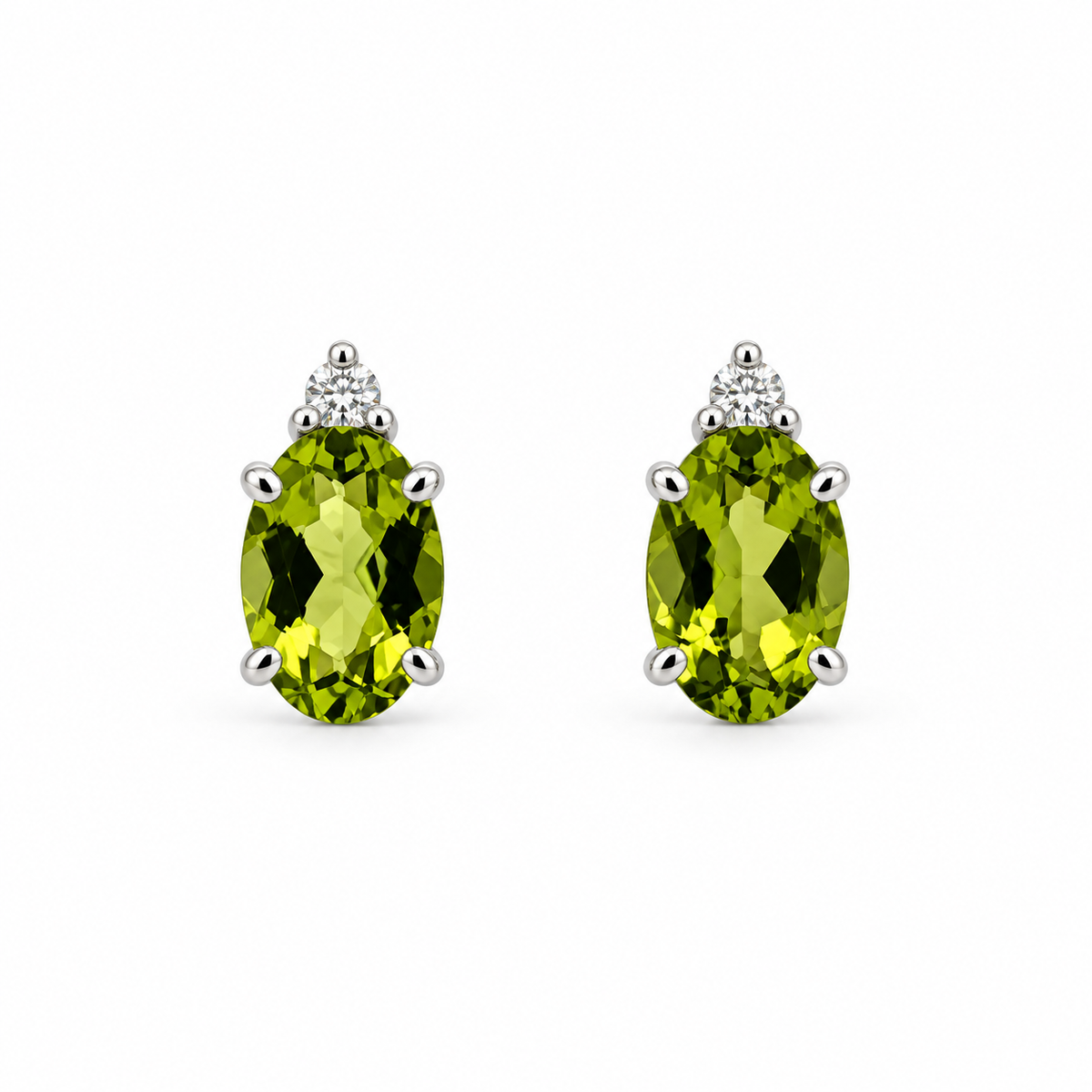 Front view of 14K white gold oval peridot and diamond stud earrings on a white background