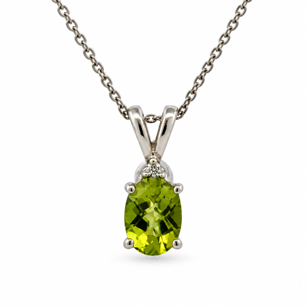 Front view of 14K white gold oval peridot and diamond pendant necklace on a white background