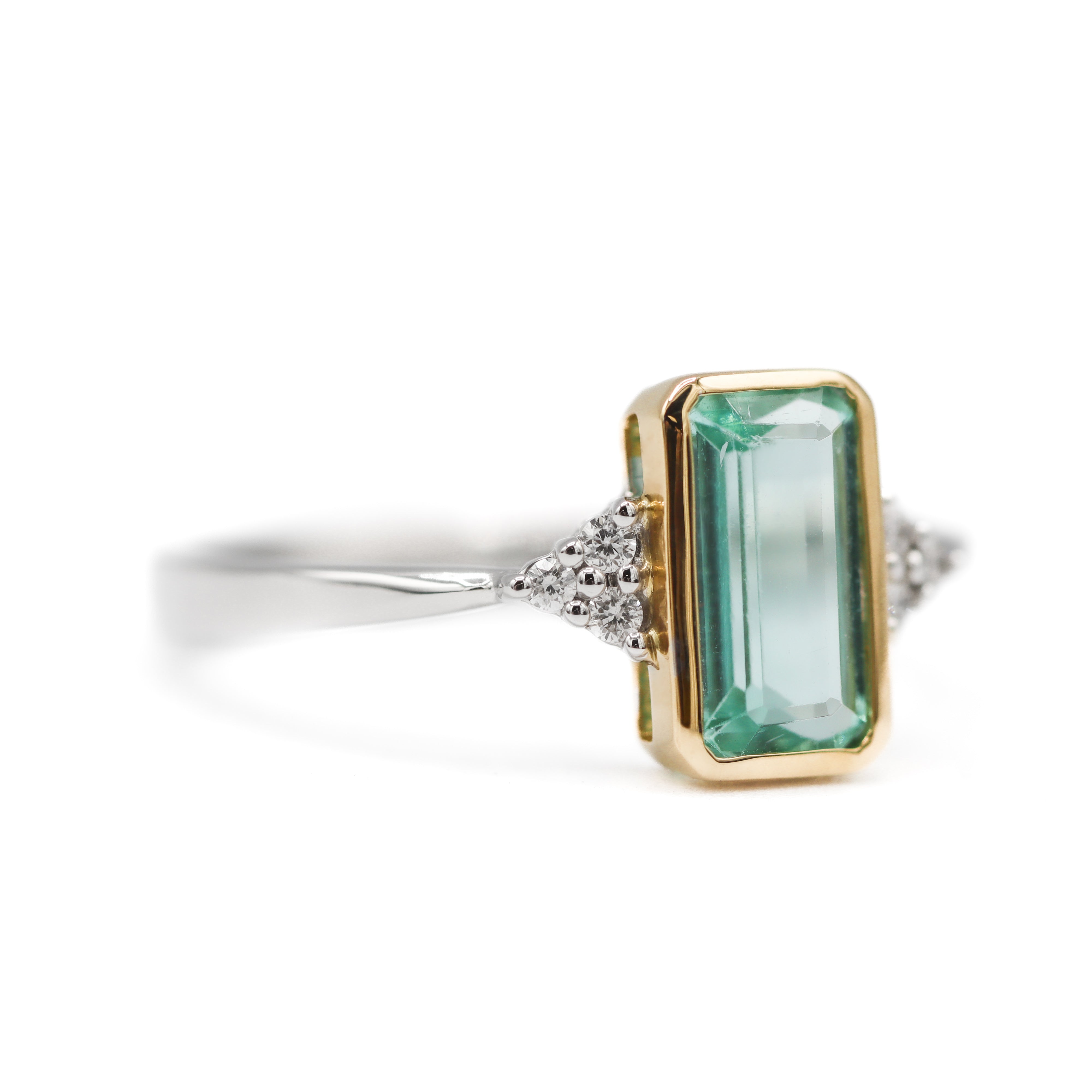 Angled towards the right view of 14K Two-Toned Emerald-Cut Mint Green Tourmaline & Diamond Ring on white background.