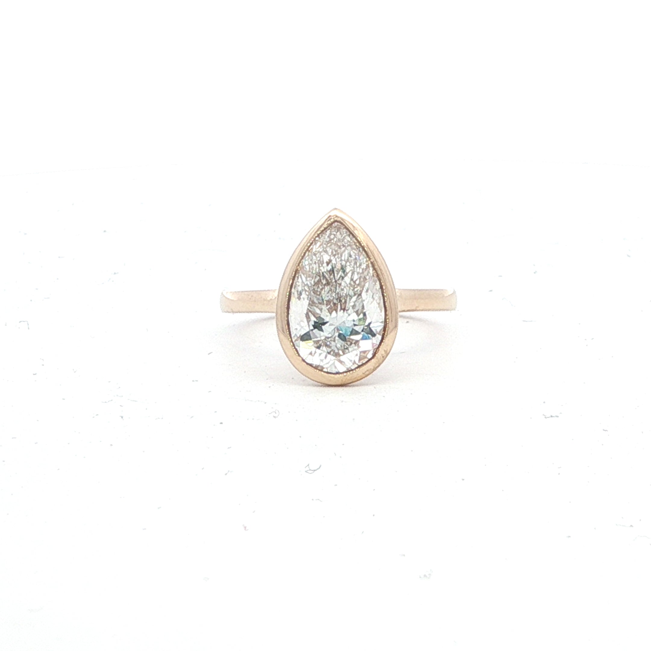 Teardrop-shaped diamond ring on a white background