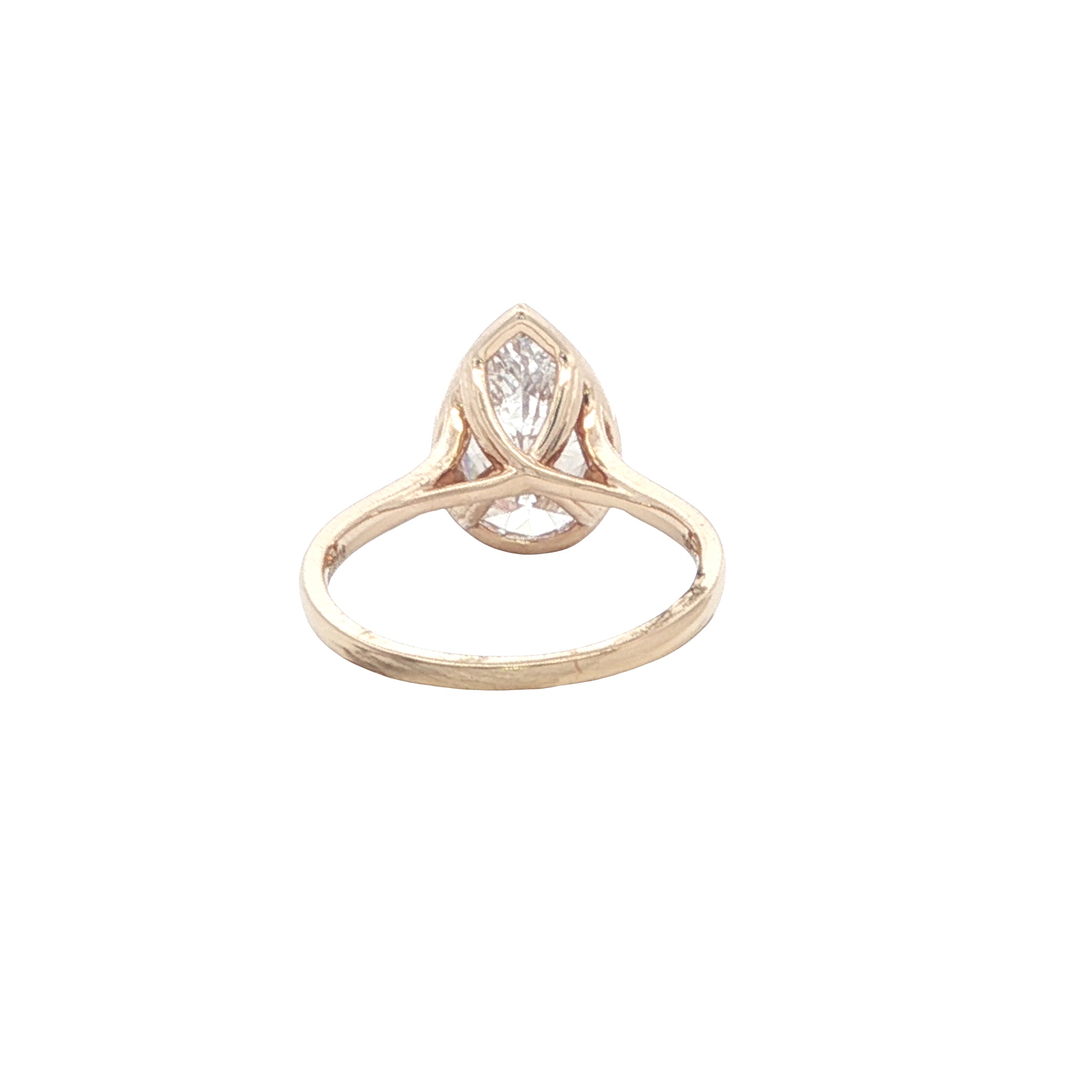Gold ring with a pear-shaped diamond on a white background