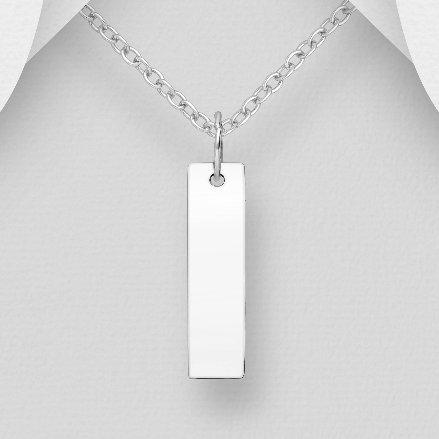 Silver necklace with a rectangular pendant on a mannequin.