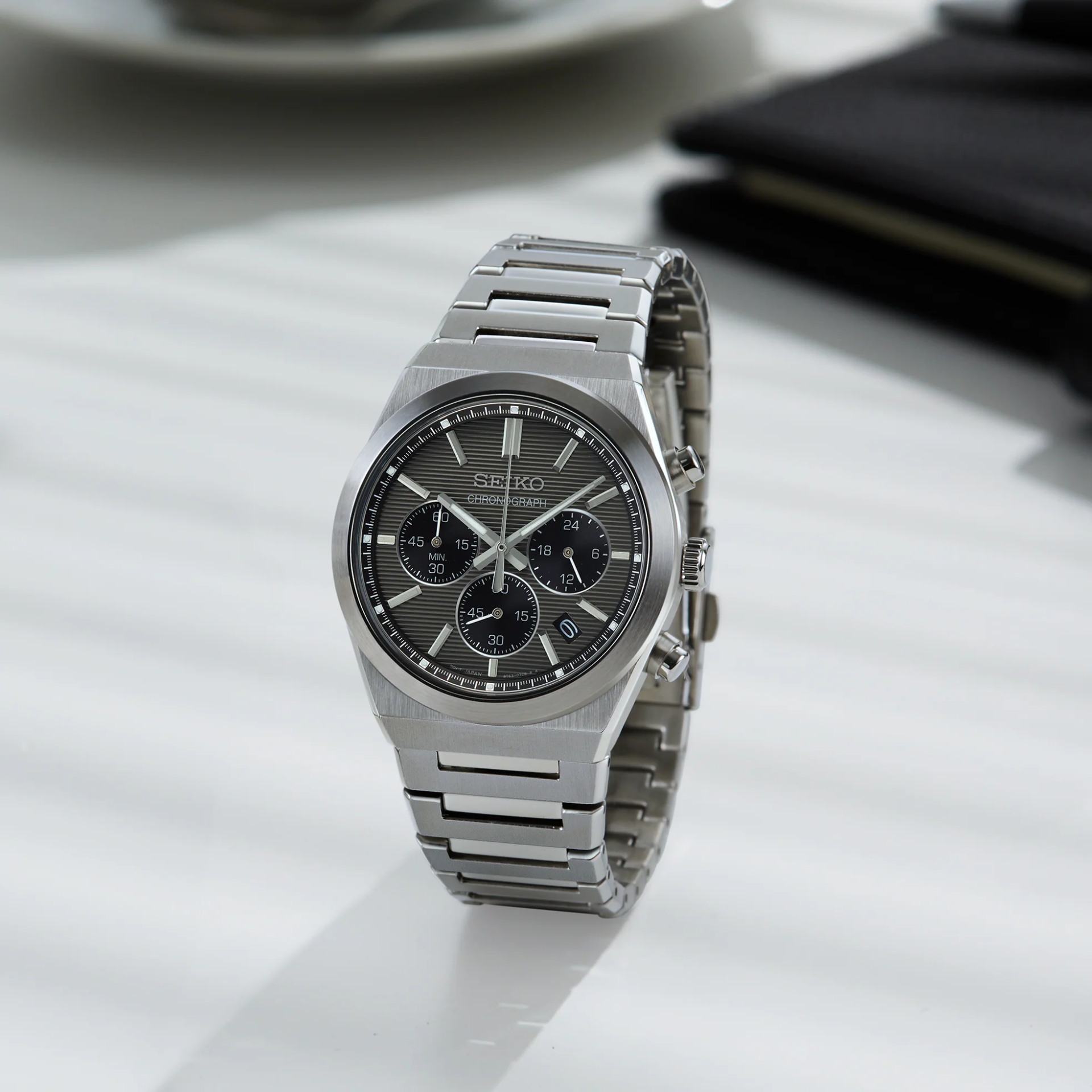 Silver Seiko watch on a light gray surface