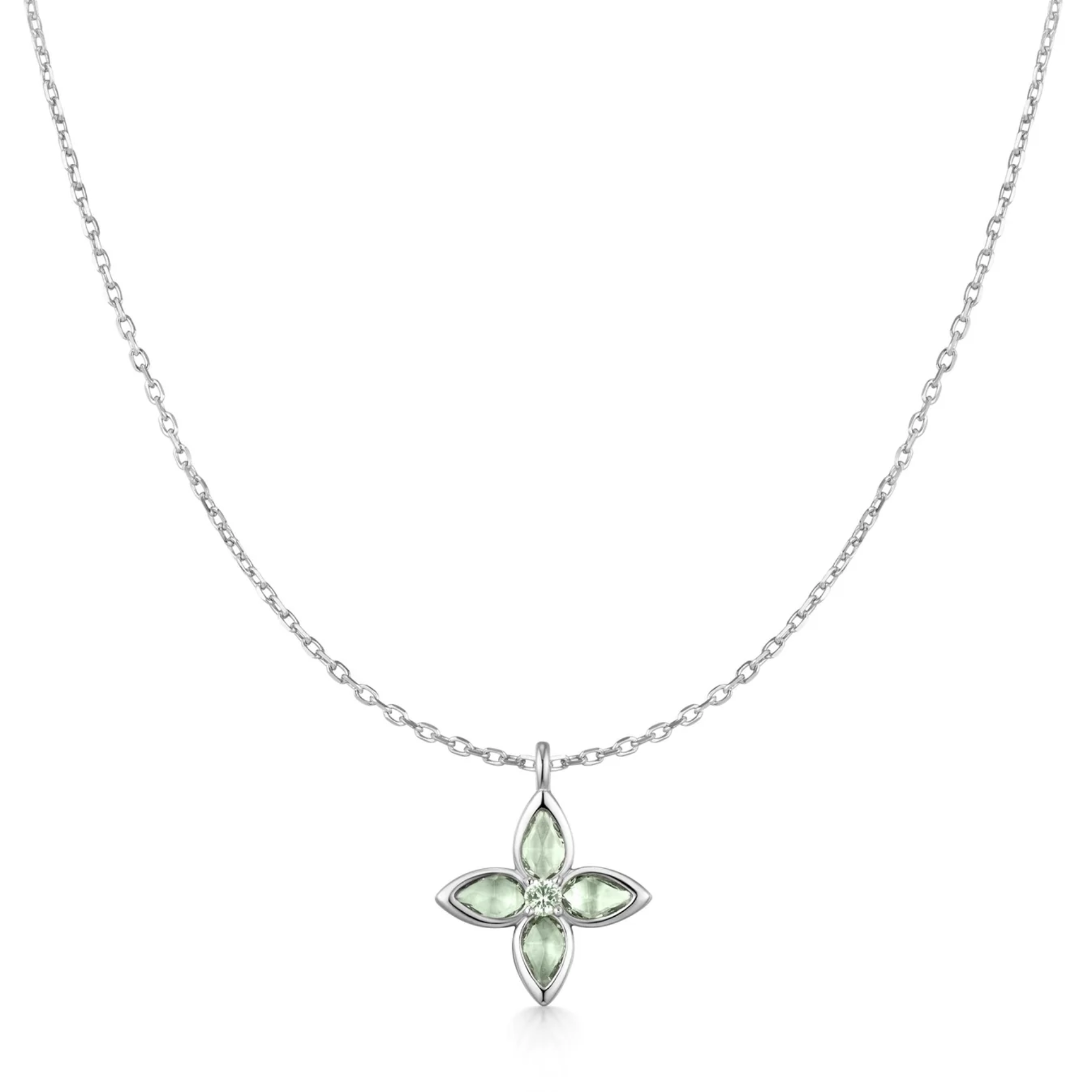 A delicate silver chain necklace featuring a small four-petal cross pendant with light green marquise-cut stones and a tiny clear center stone, shown on a plain white background.