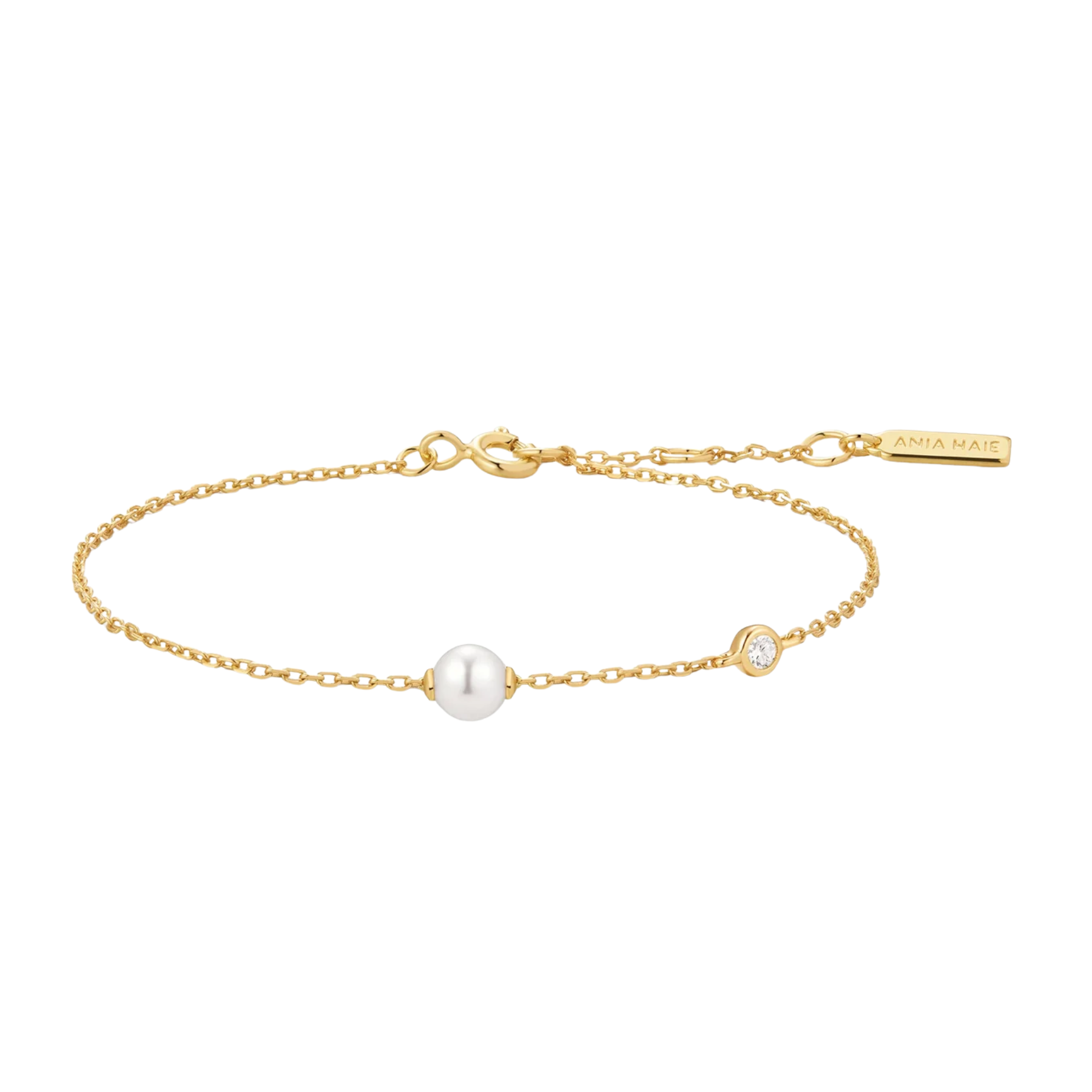 A delicate gold chain bracelet featuring a central white pearl and a small bezel-set clear stone, with an extender chain and a branded tag reading 'ANNA MARIA'.