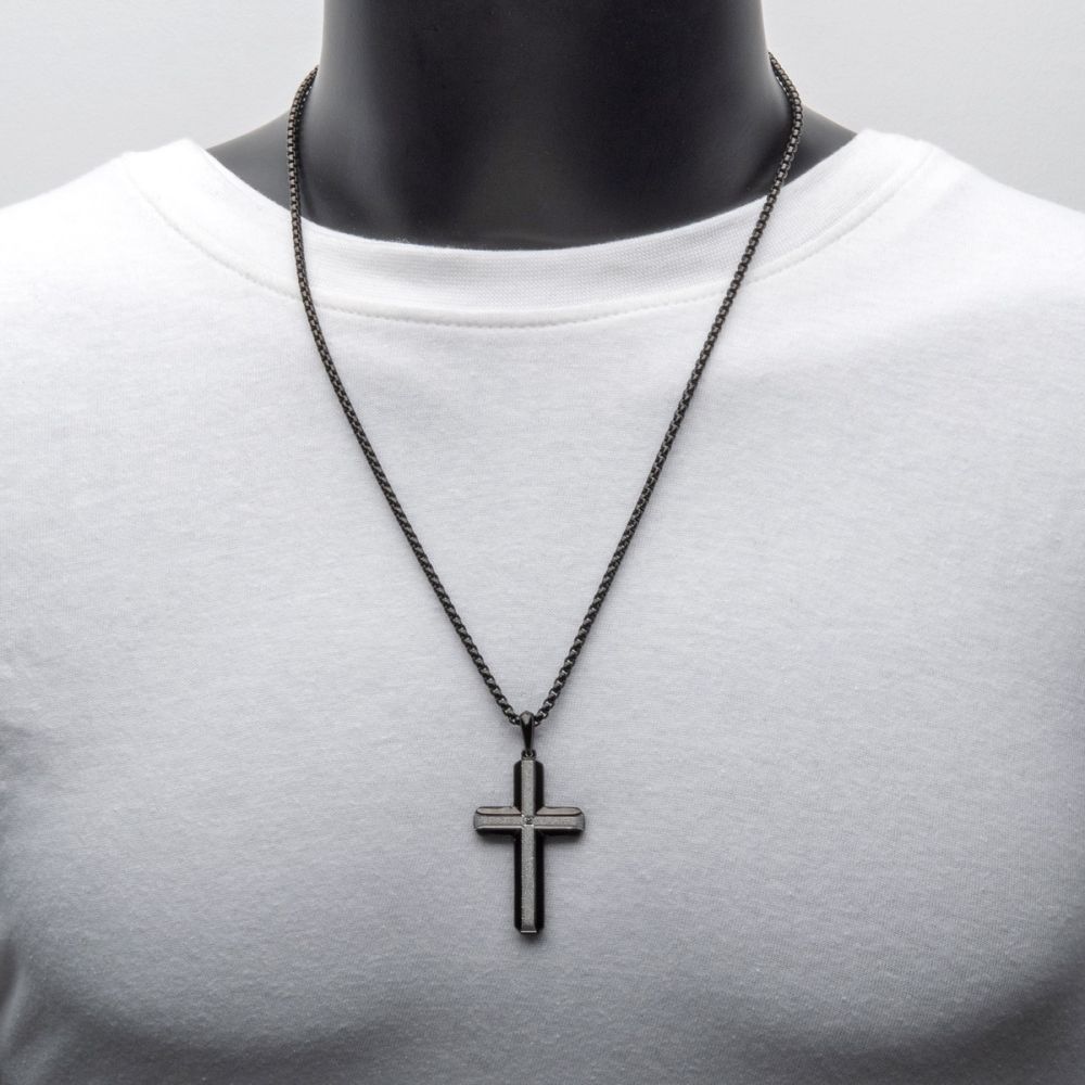 Black cross necklace on a mannequin with a white shirt