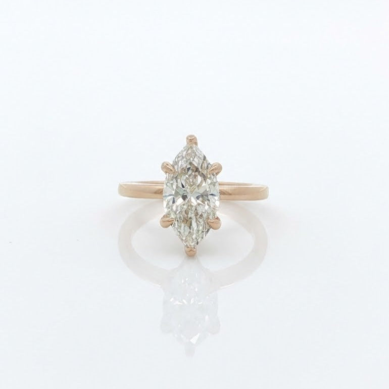 Diamond ring with a pear-shaped center stone on a white background